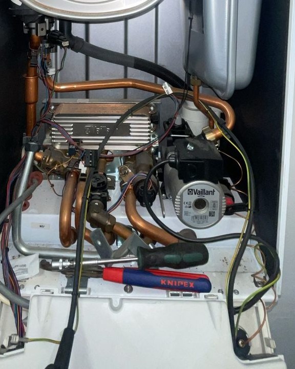 Koperen leidingen en de pomp in een geopende ketel