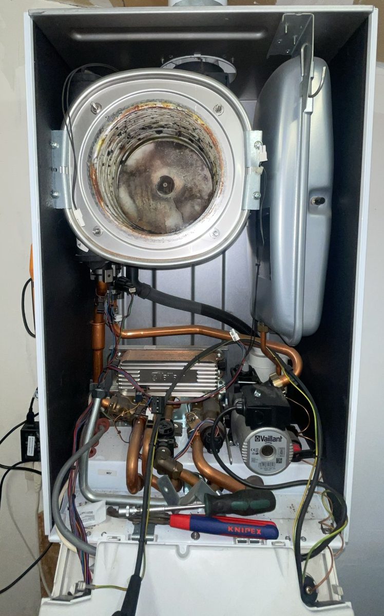 Een geopende Vaillant-ketel tijdens een onderhoud, met het gereedschap erbij